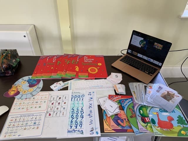Educational materials and a laptop arranged for a Cuckmere Training session